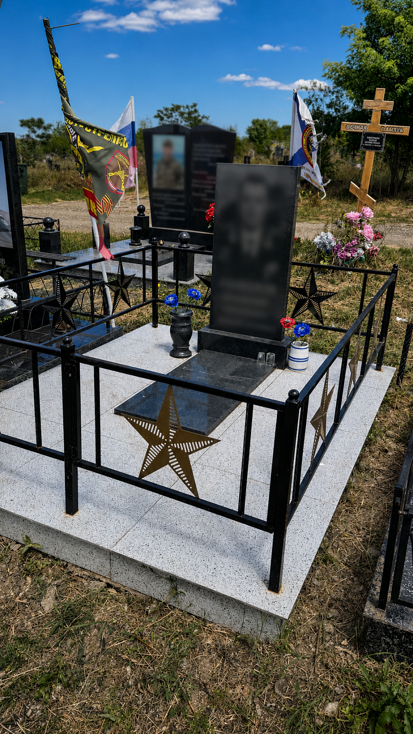 Памятник военному из габбро-диабаза с оградой и звездой