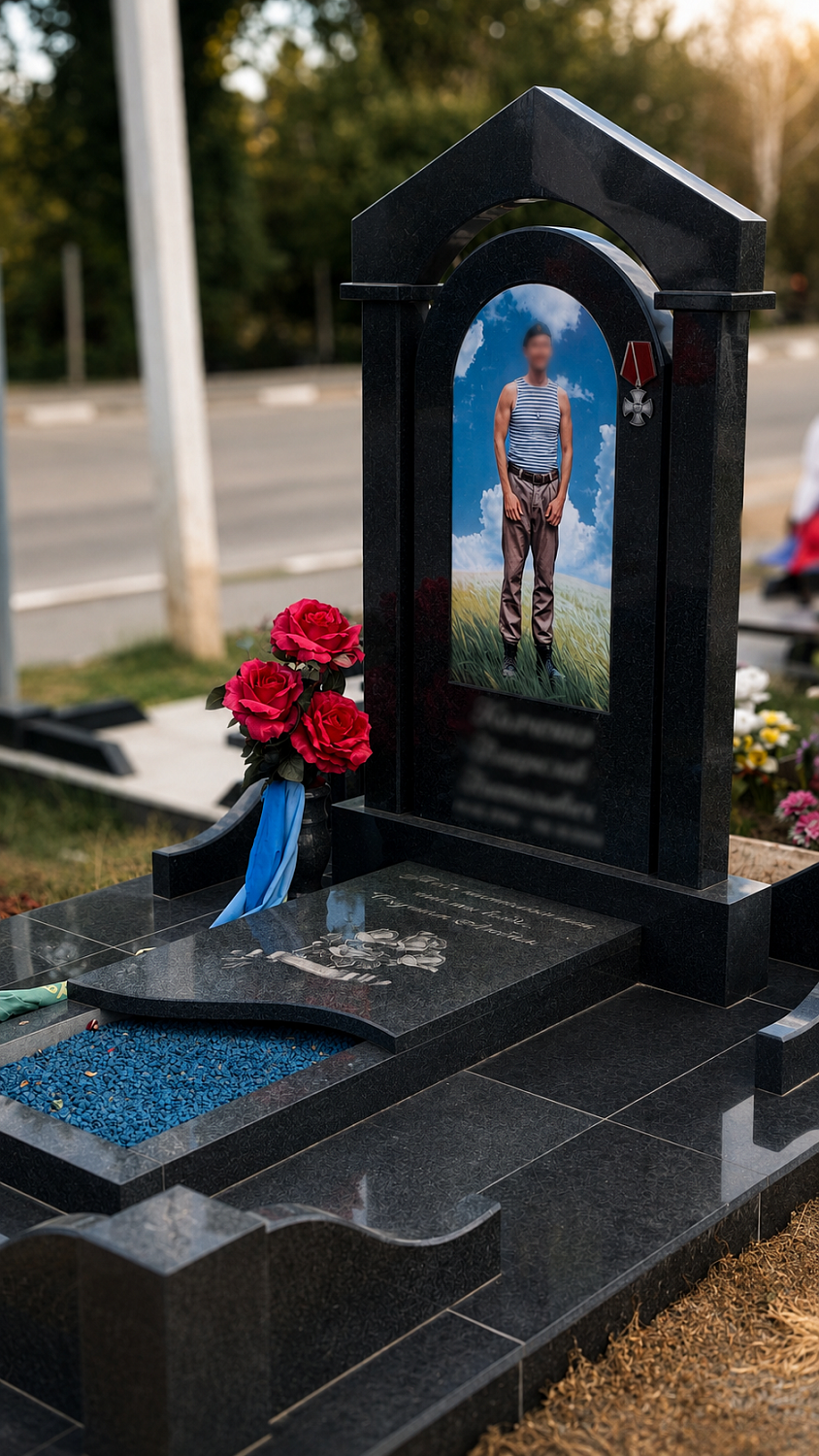 Памятник военному из габбро-диабаза с арочной стелой, цветным портретом и открытым цветником